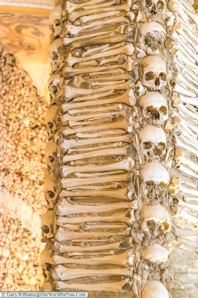 A close-up of skulls & bones that adorn one of the columns in the Chapel of Bones in Évora