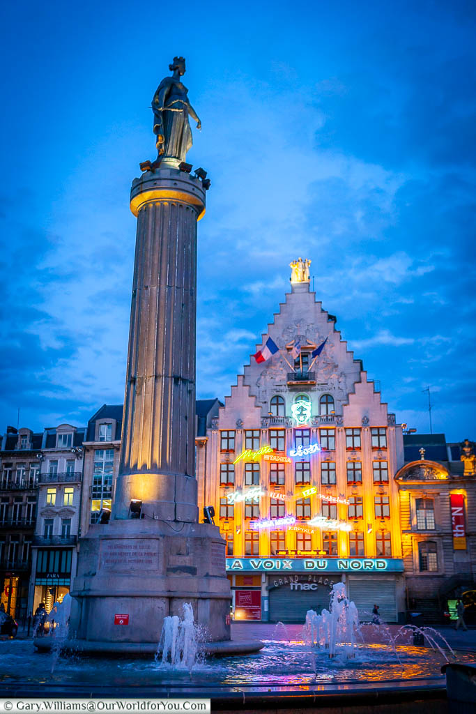 The Column of the Goddess of the Place du Charles de Gaulle at dusk under a blue sky.