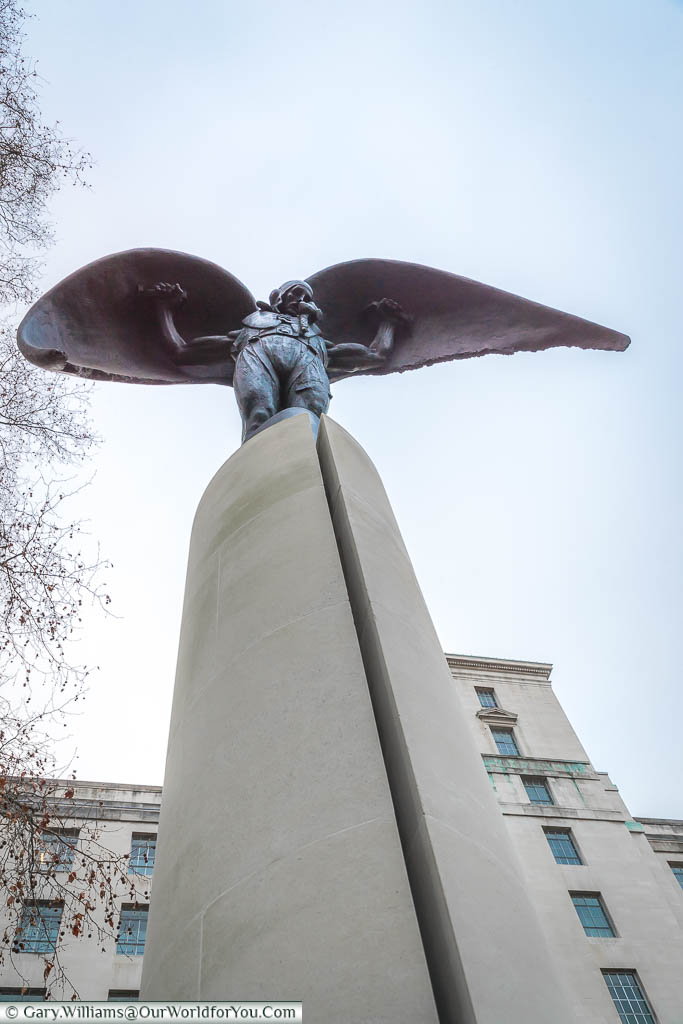The Fleet Air Arm Memorial comprises a thin stone column on which stands a bronze statue of a naval airman, wearing a flying suit and helmet, and with wings attached to his arms like Daedalus from Ancient Greek mythology, resembling a winged victory or an angel.