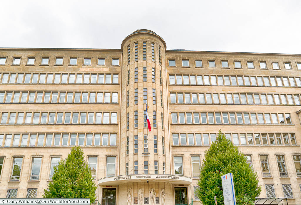 The art deco styled building of the Prefecture Services Administration in Caen.  The circular central column of the golden sandstone building is flanked on either side by offices over seven floors.