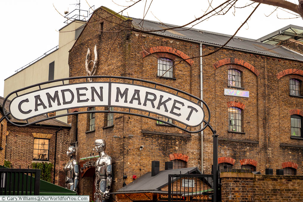 The Camden Market sign over the Chalk farm entrance in front of the old industrial brick buildings.