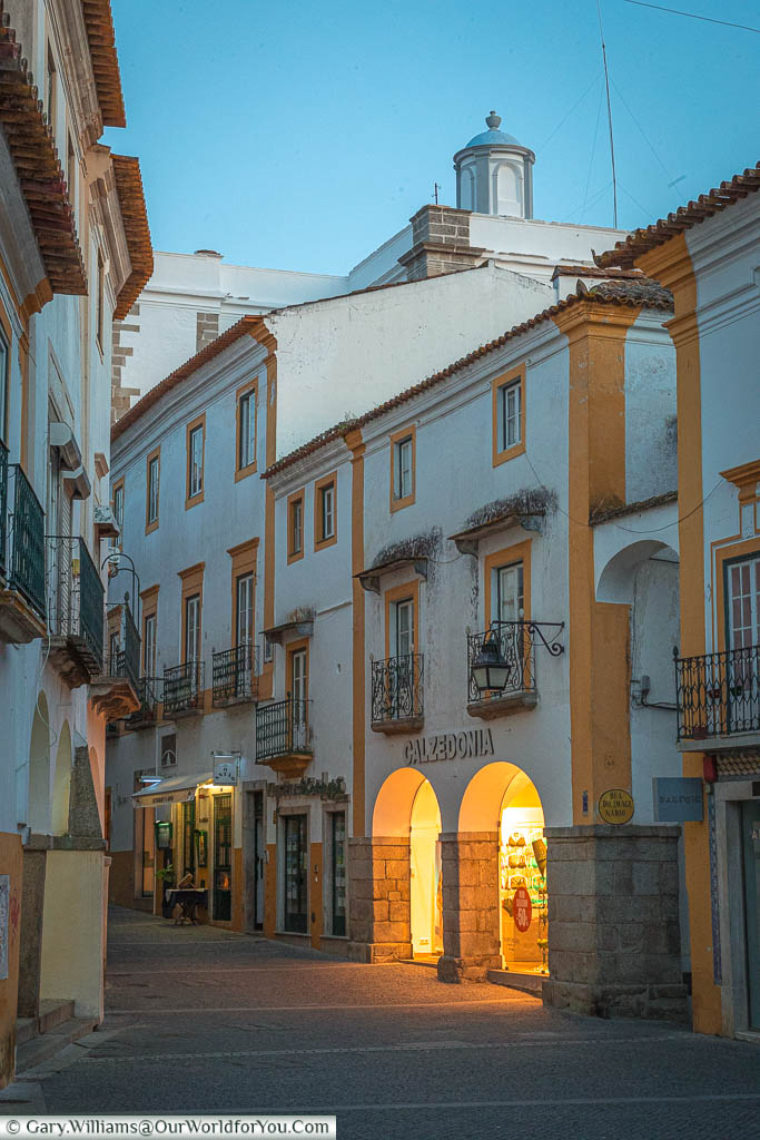 The lights of a gift store reflect onto a quiet lane in Évora as it meanders through the town.