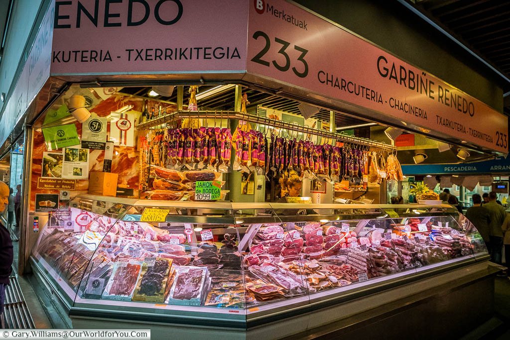 Cured meat hanging from a stall in the Mercado de la Ribera, Bilbao, Spain