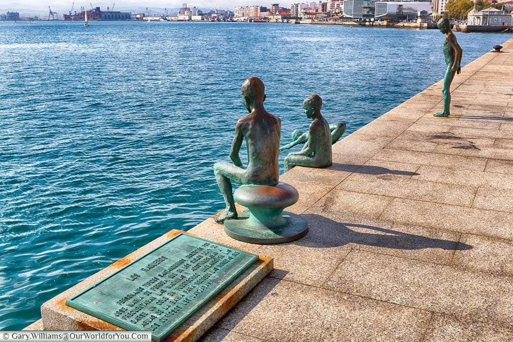 A plaque next to four bronze statues depicting young boys diving into Santander's natural harbour.