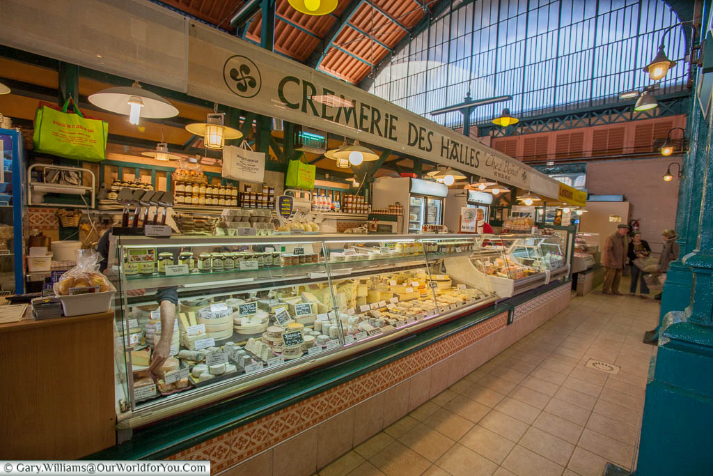 A French dairy stall inside the Les Halles de Saint-Jean-de-Luz packed with regional cheeses.