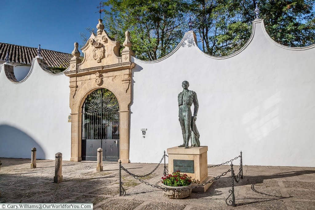 A statue to a matador, in front of the walls that surround Ronda's bullring.