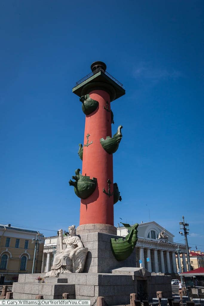 One of the Rostral Columns on the banks of the Neva River, Saint Petersburg, Russia.  The Doric column sit on a granite plinth and is constructed of brick coated with a deep terra cotta red stucco and decorated with bronze anchors and four pairs of bronze ship prows.