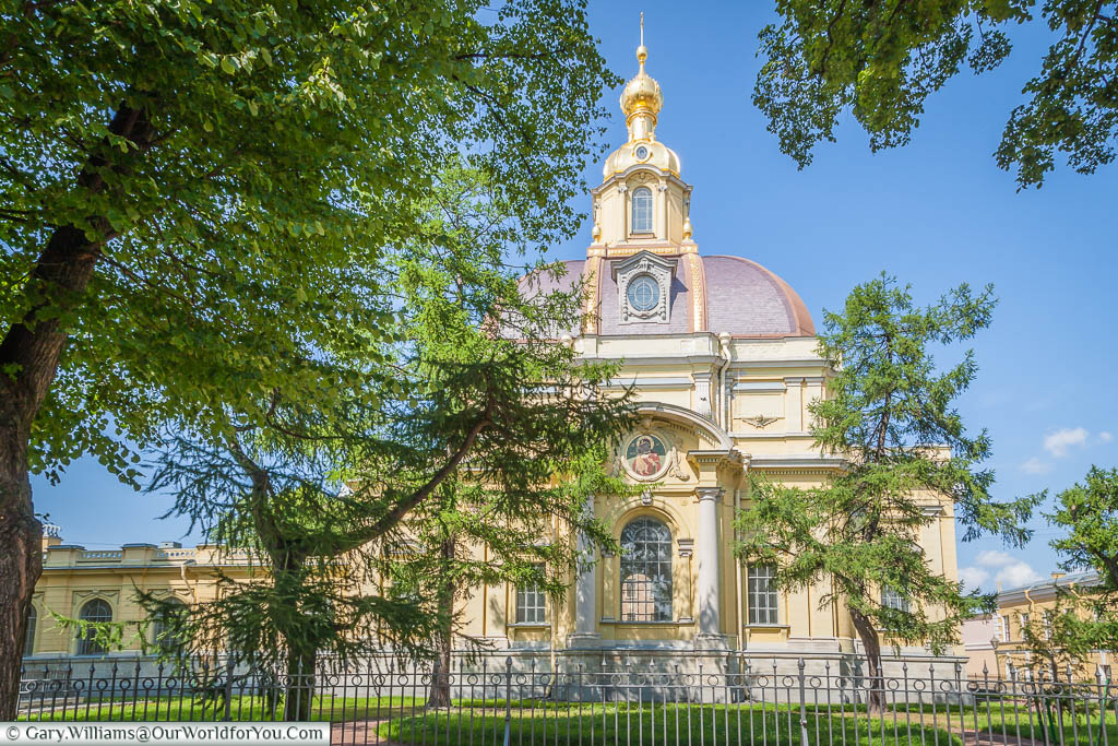 Looking through a wooded garden to the gold-topped Grand-Ducal Burial Vault next to Peter and Paul Cathedral, Saint Petersburg, Russia