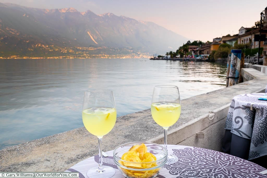 Two glasses of Limoncello Spritz at a bar table next to Lake Garda in Limone-sul- Garda, Italy