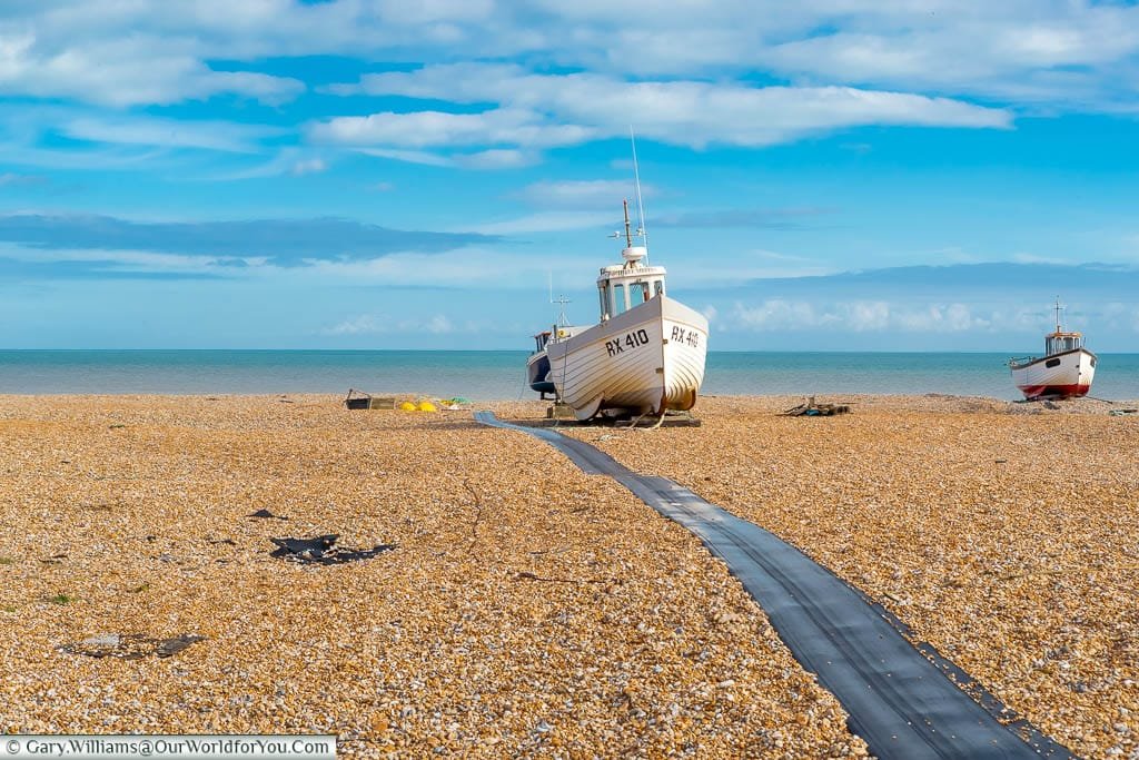 A couple of small fishing boats on the cobbled beach of Dungeness