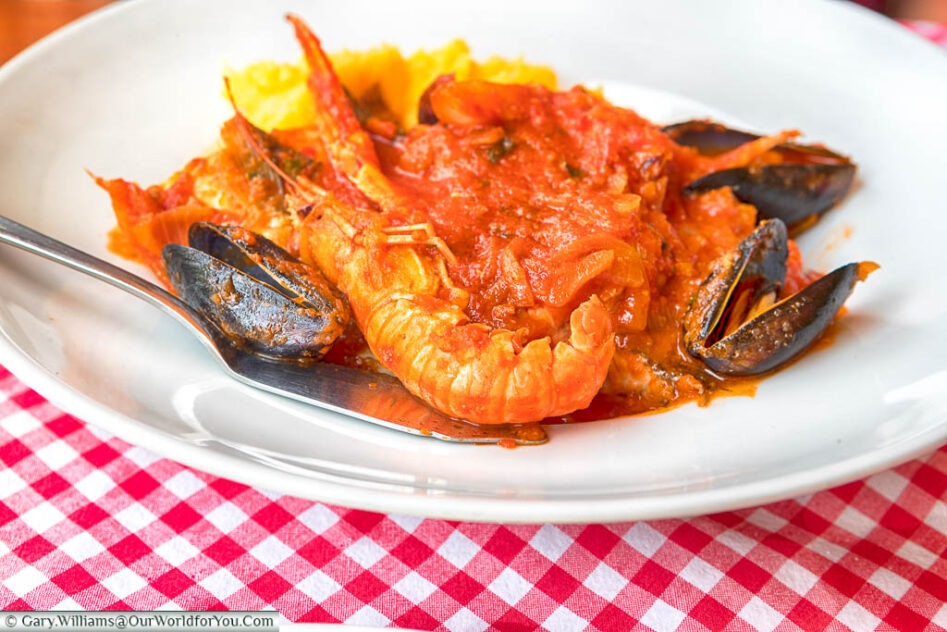 A Croatian seafood brodet stew consisting of giant prawns & muscles in a tomato sauce, served with polenta