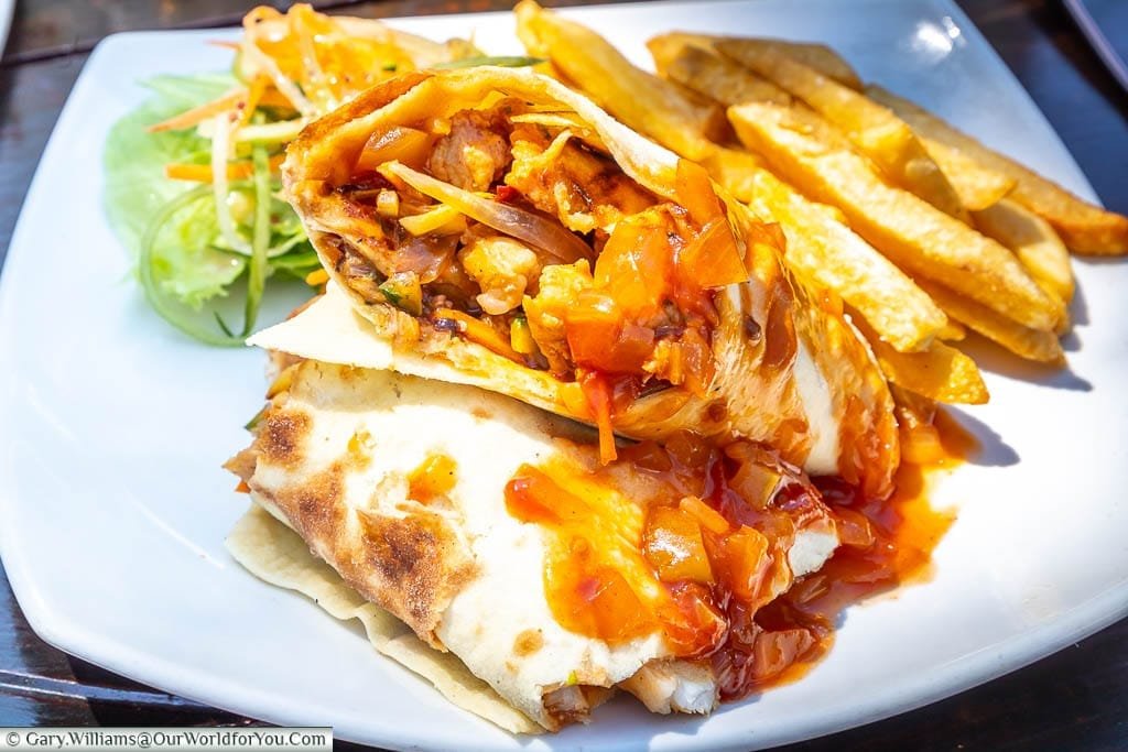 A crocodile wrap, cut in half and served with a sauce & fries in Zimbabwe