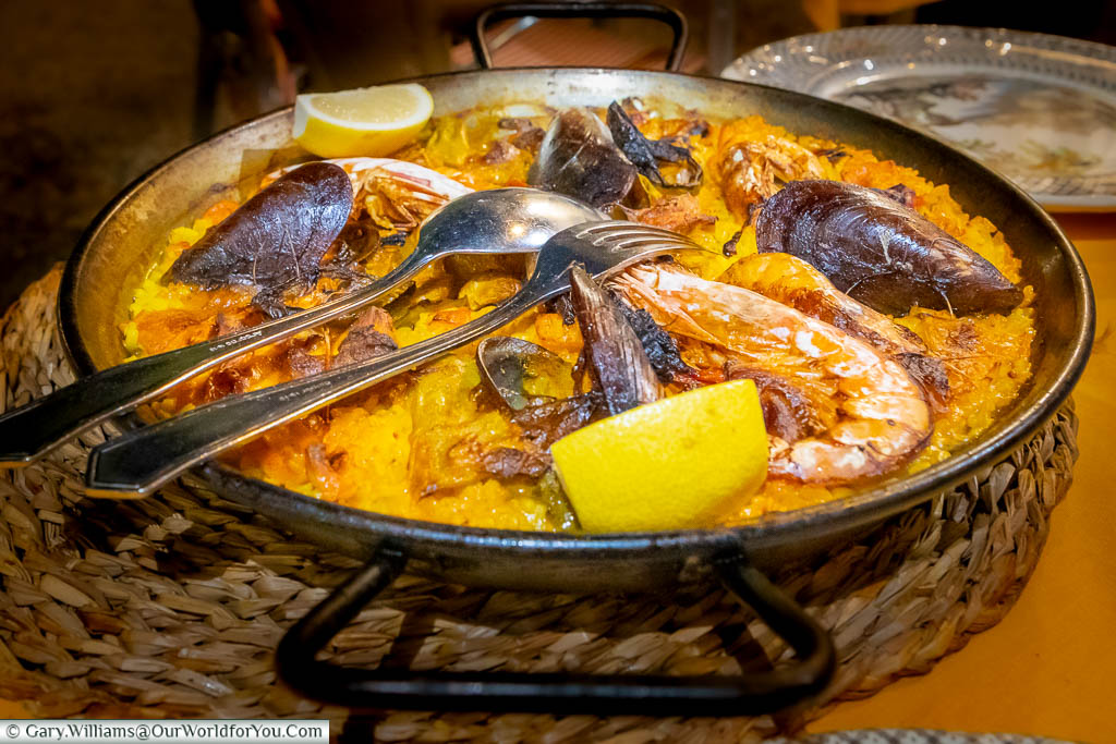 A large iron pan of saffron-coloured paella with mussels and giant prawns to share.