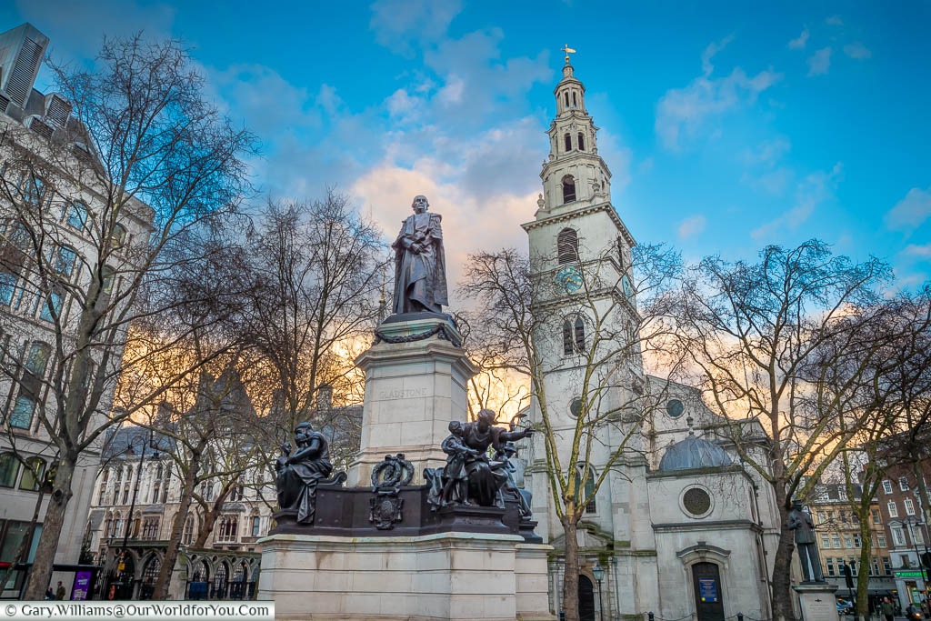 A statue to William Gladstone in front of St Clement Danes Church at dusk