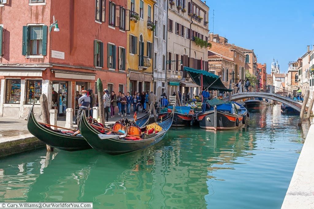 A pair of gondolas and the fruit & vegetable barge by the Ponte dei Pugni or Bridge of fists in Venice