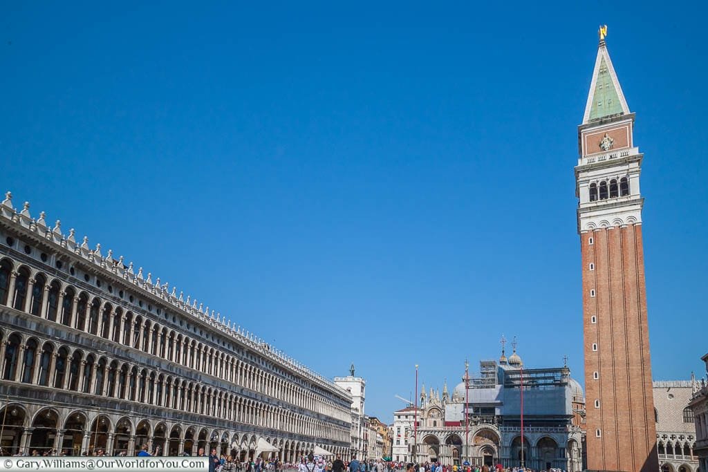 A view overlooking the bustling Piazza San Marco, with the colonnades to the left and the Campanile to the right with the Basilica di San Marco in the background