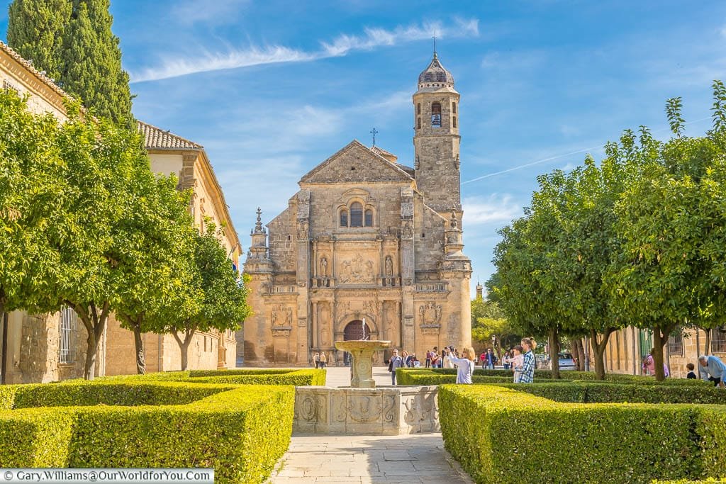 Tree edge carefully trimmed box hedges around a fountain in the gardens in front of the stone El Salvador Chapel in Úbeda, Spain