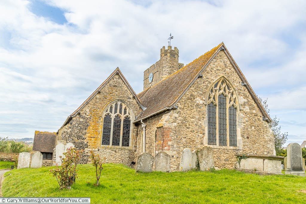 The small flintstone All Saints Church in Wouldhamas seen from the lychgate