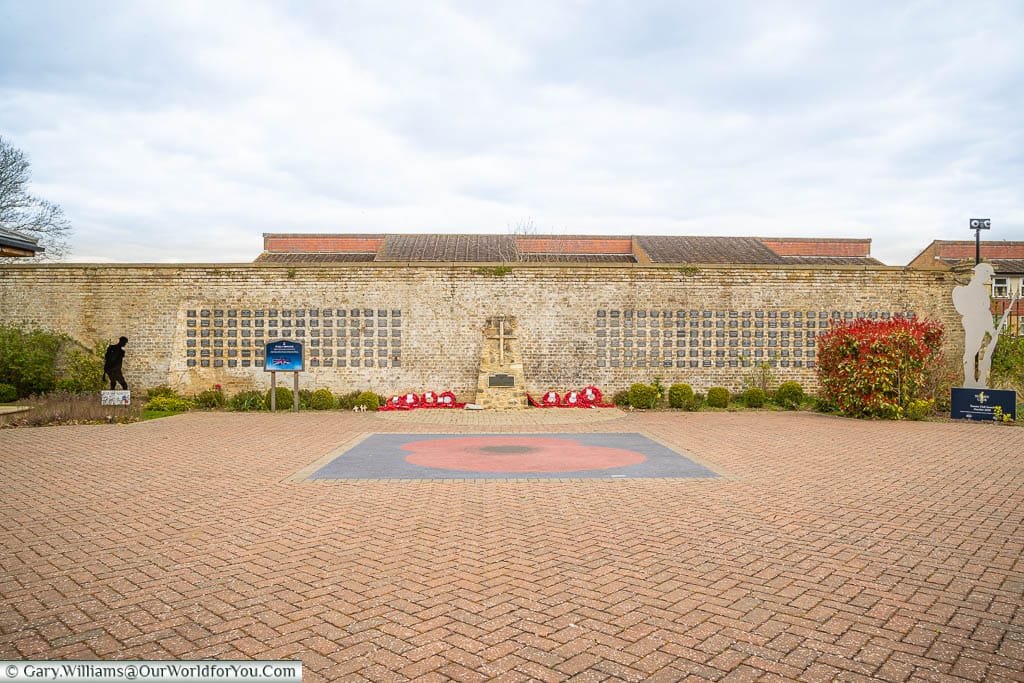 A poppy set into the square in front of the Wall of Honour in the memorial gardens of the Royal British Legion Villiage