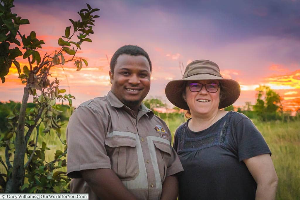 Danny and Janis posing in front of a beautiful African sunset at a rest point in our evening safari.