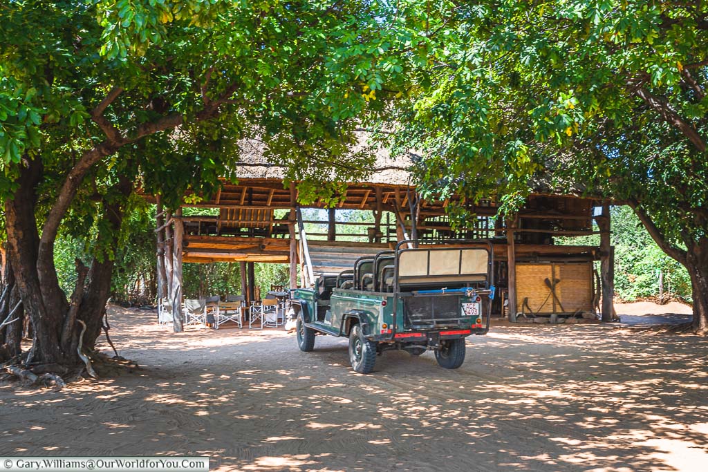 The Land Rover Safari truck parked in front of the boma at Rhino Safari Camp next to Lake Kariba in Zimbabwe