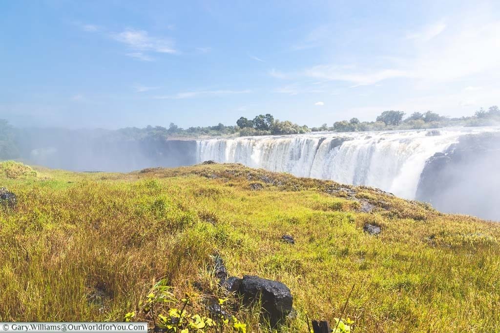 The lush green grass in front of the gorge and Victoria Falls from the Zimbabwe side