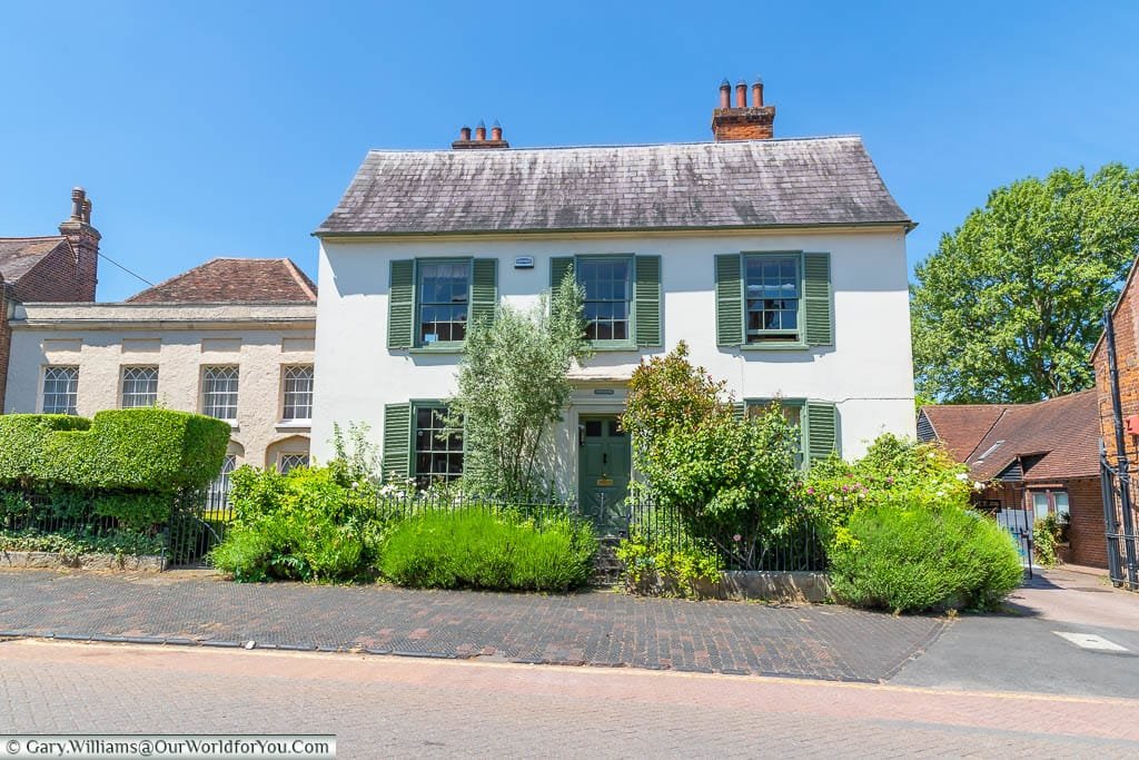 A white beautiful detached home with green shuttered windows on West Malling High Street