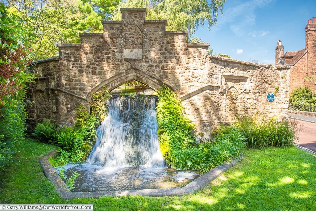 Water cascading down a 1.5-metre man-made waterfall through a medieval stone arch at the rear of St Mary’s Abbey in West Malling Kent