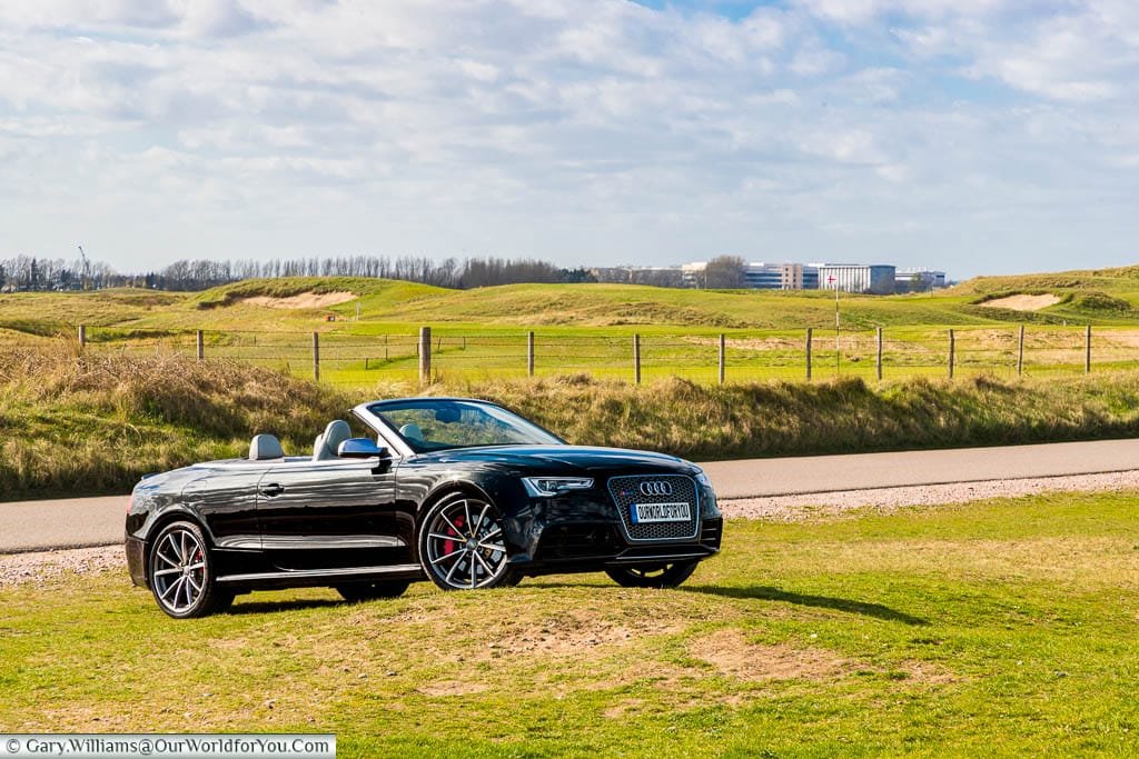 Our black Audi Convertible, with the roof down, parked on the edge of the Royal St George’s Golf Club, Sandwich, Kent