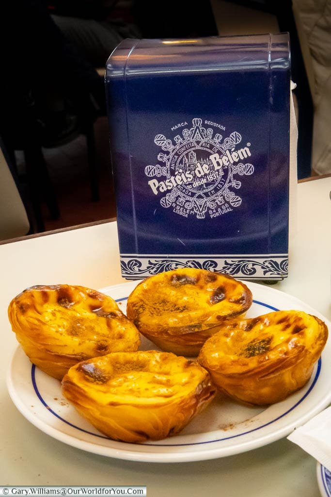 A plate of four Portuguese custard tarts at Pastéis de Belém in Lisbon, Portugal