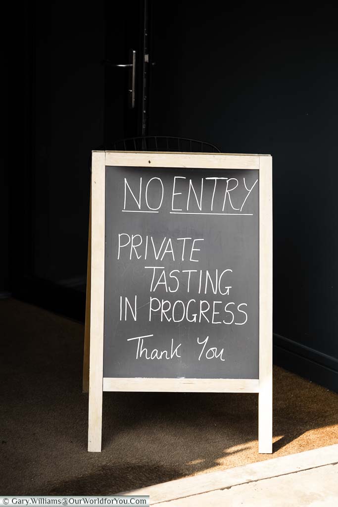 A chalkboard at the entrance to the Wine Sanctuary informing you that wine tasting is in progress.