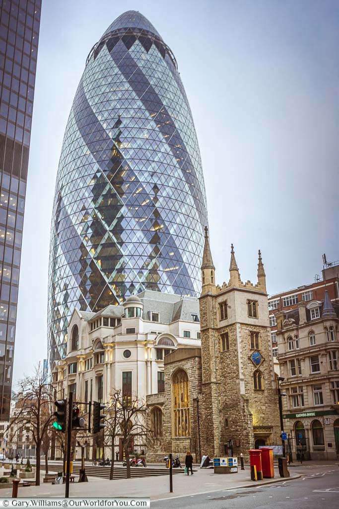 The modern 30 St Mary Axe, better known as the Gherkin, standing behind St Andrew Undershaft Church in the City of London
