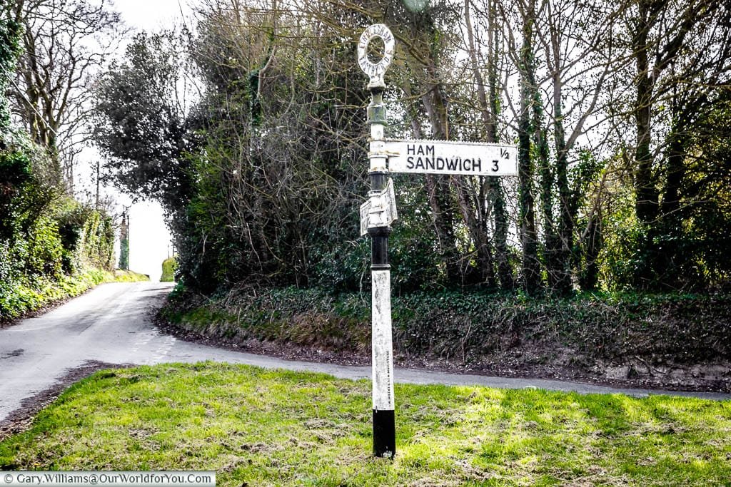 The cast-iron street sign with directions to the hamlet of Ham, and the town of Sandwich, creating a Ham Sandwich sign, just outside Sandwich, Kent