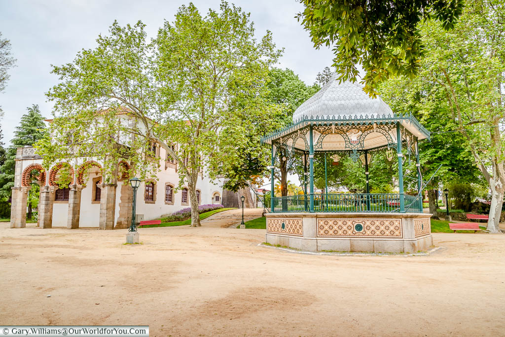 An ornate bandstand and the moorish Royal Palace of Évora or Palácio de Dom Manuel in Évora, Portugal