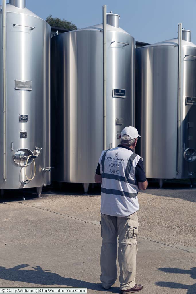 Tony standing in front of the stainless steel vats explaining the process one the wine has been pressed and transferred to these containers.