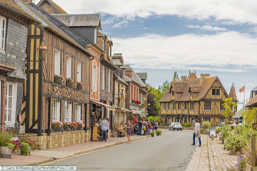 The main route through Beuvron-en-Auge, on Normandy's Route de Cidre,  with half-timbered houses lining one side.