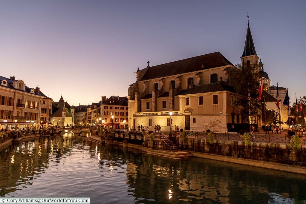 A view over the canal fed off Lake Annecy at dusk with the church of Saint-François de Sales dominating the skyline.