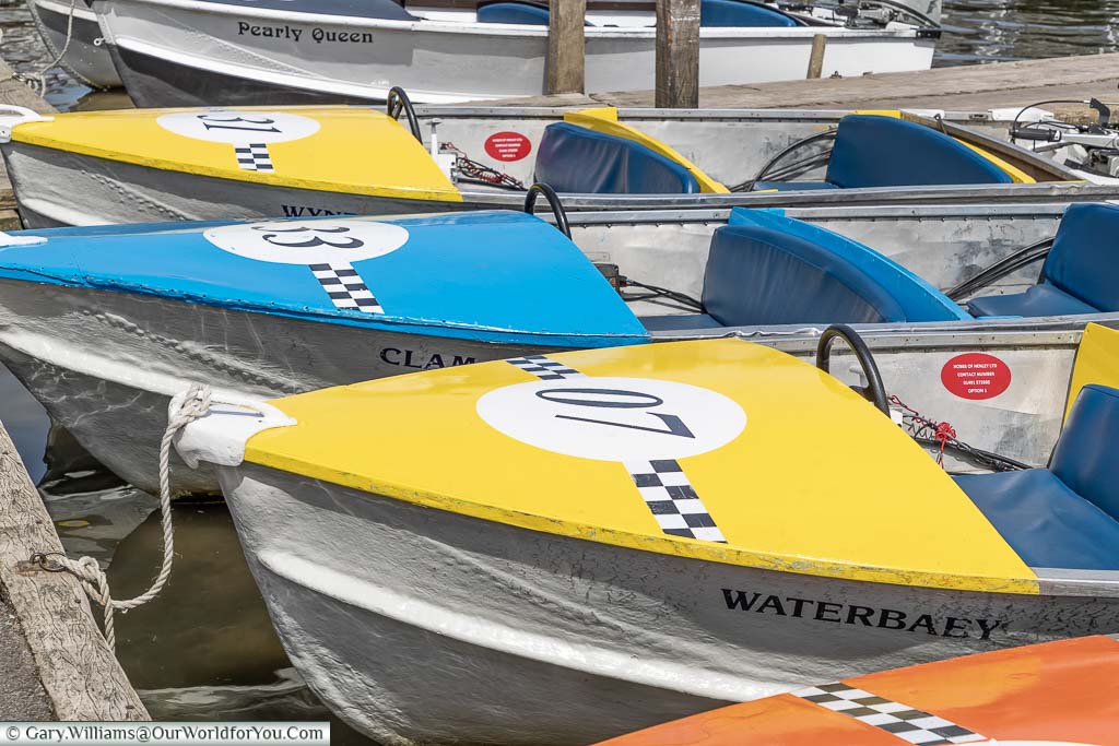 A close-up of the row of brightly coloured motor boats for hire at Henley on Thames