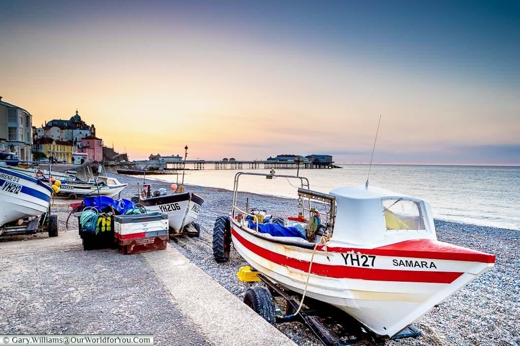 A small fishing boat on the shore at Cromer at dusk