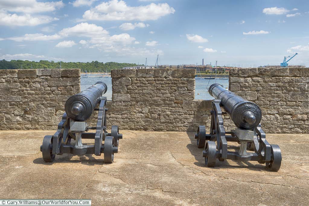 Two cast-iron cannons, placed behind a short stone wall, to the River Medway beyond