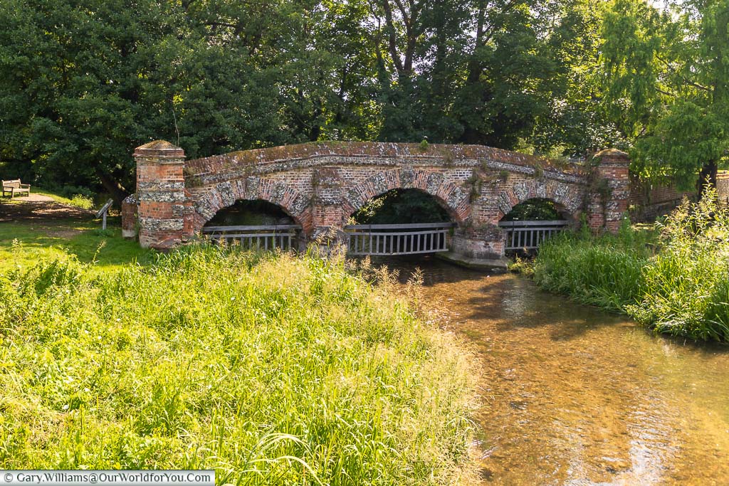 A brick-built, three arch structure, with wooden gated suspended from each arch over the River Darent in Farningham, Kent