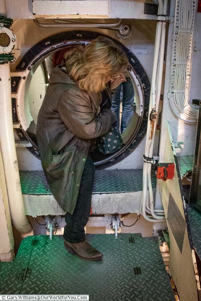 Janis clambering through one of the hatches on board HMS Ocelot at the Historic Dockyard Chatham