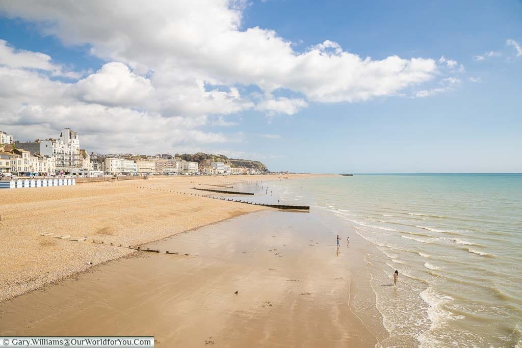 The view of Hastings beach and seafront from the pier on a bright sunny day