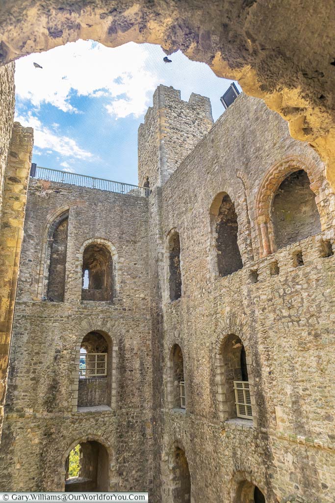 Looking through an archway, inside of the ruins of Rochester Castle, to one of the square corner towers