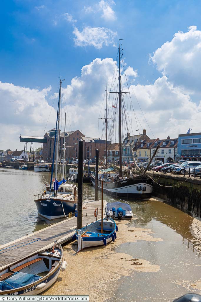 Tall sailing ships moored up on the quayside of Wells-next-the-Sea on the North Norfolk coastline