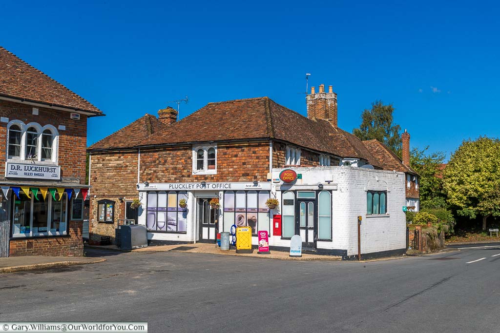 A traditional butchers and post office in the village of Pluckley, Kent on a beautiful day under blue skies.
