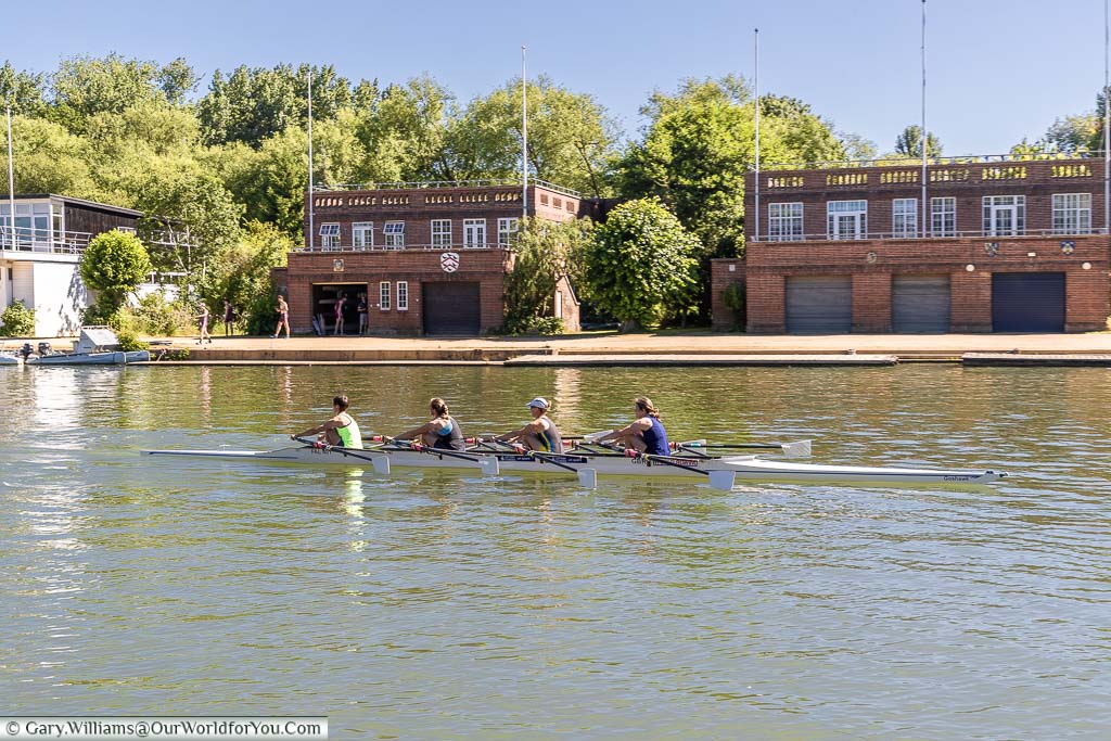 A four-person crew training in front of the different rowing clubs on the banks of the River Thames at Oxford