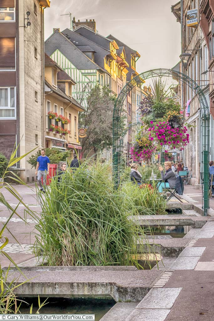 A stream flowing along a restaurant-lined street in Rouen, Normandy