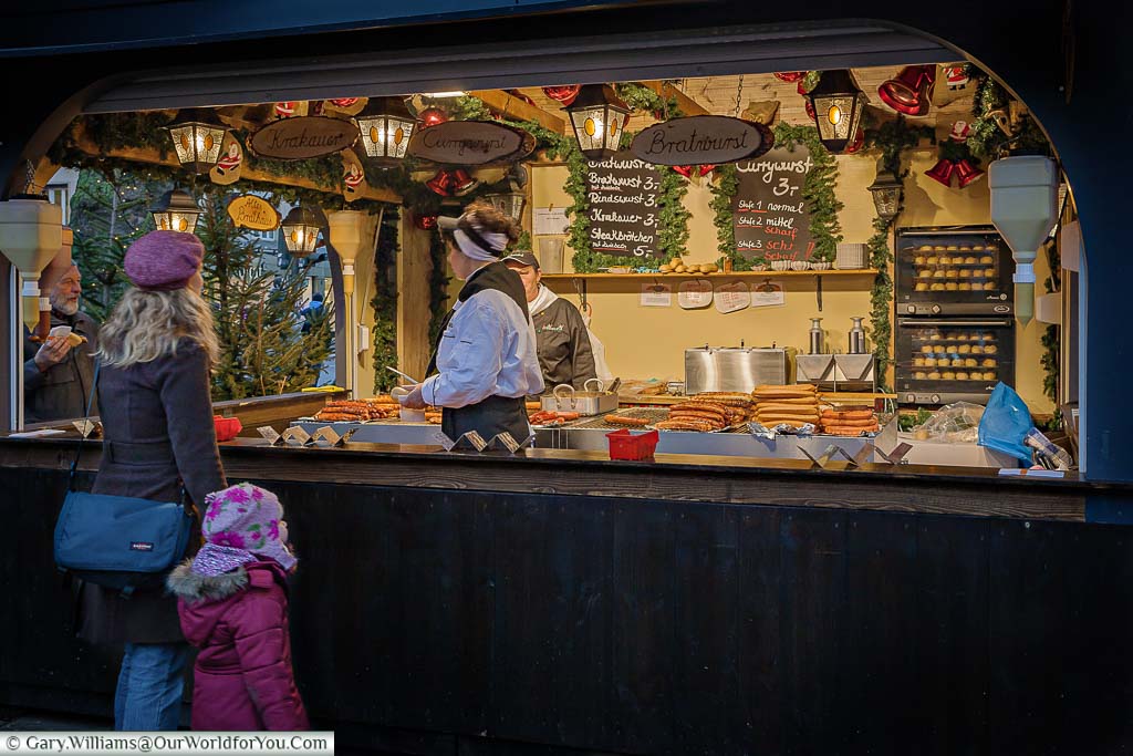 A mother and young girl at a sausage stall at the Cologne Christmas market