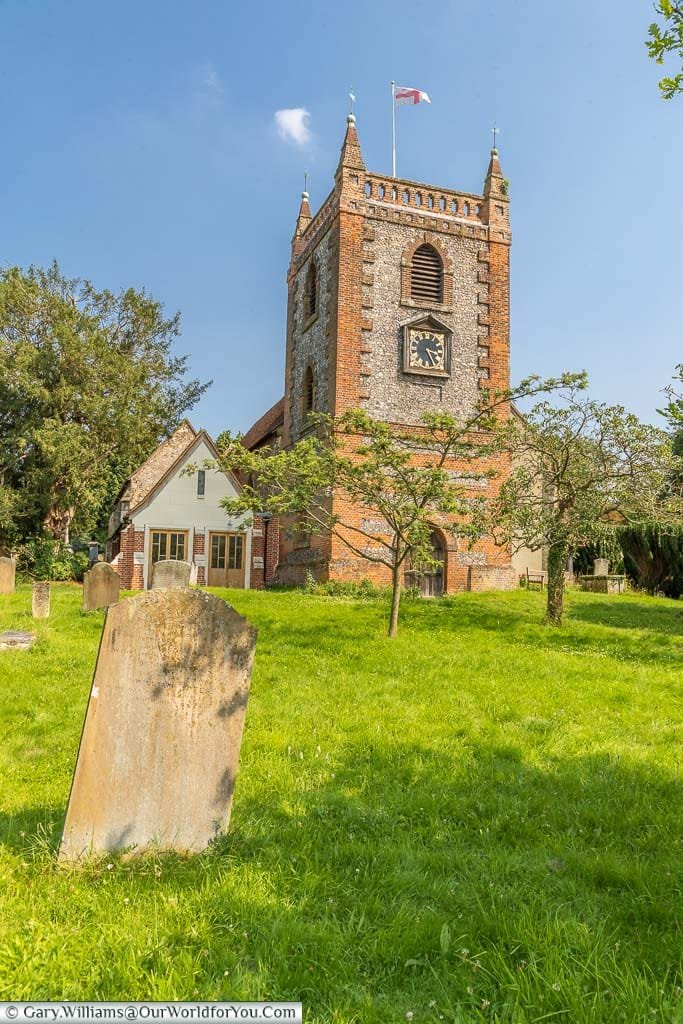 The tower of St Peter and St Paul Church in Shore, flying the cross of St George, as seen from the churchyard